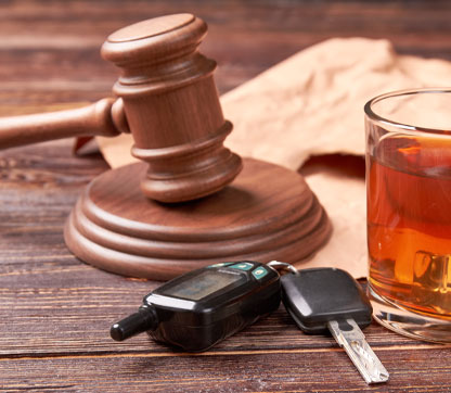 Car keys, whiskey and gavel on a table